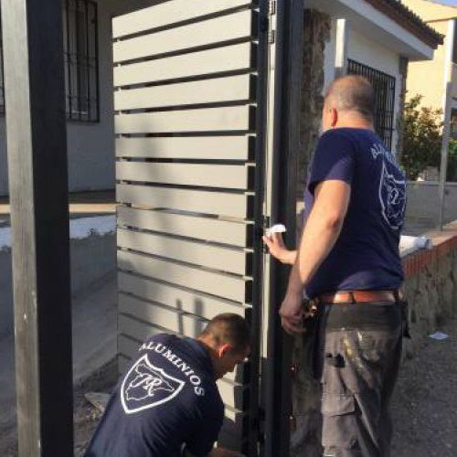 Trabajadores colocando puerta exterior en vivienda