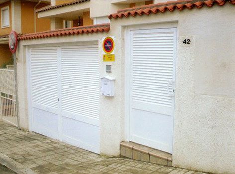 Puerta de garaje y entrada en chalet en color blanco